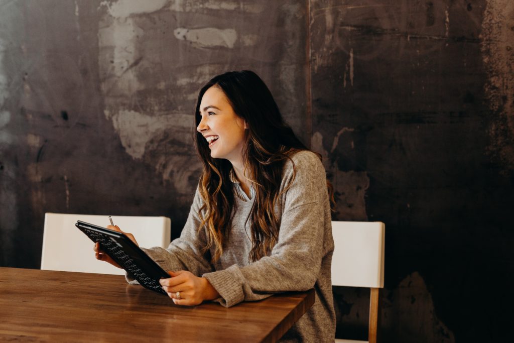 A laughing girl holds an iPad